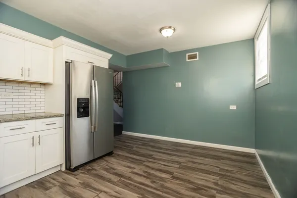 a view of an empty room with closet and a window