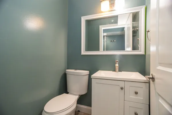 a bathroom with a toilet sink vanity and mirror