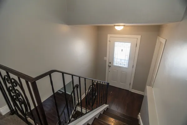 a view of a hallway with wooden floor and stairs