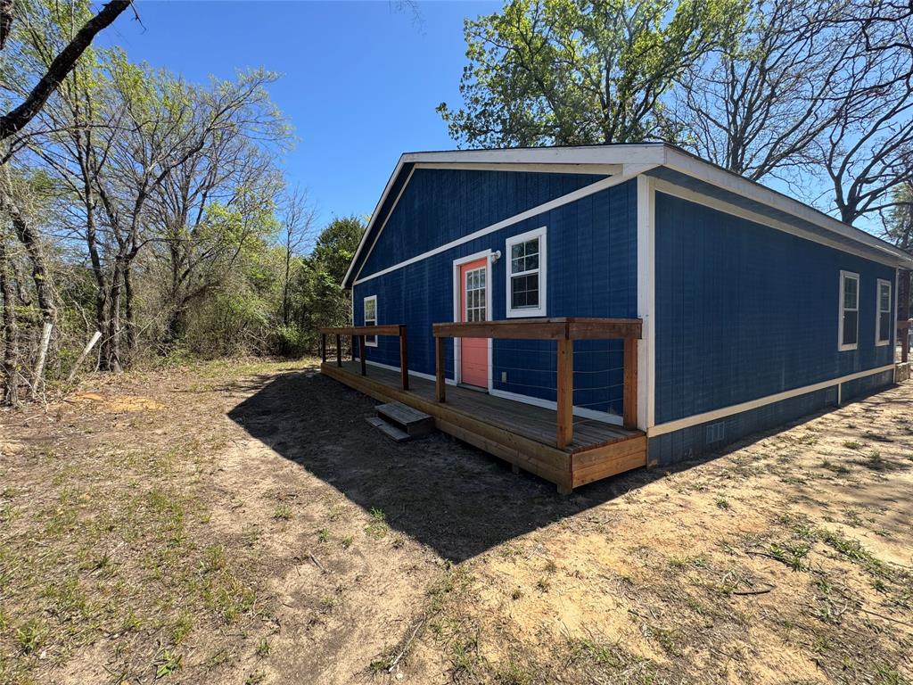 232 West Quanah Road Mabank, TX 75156 - Photo 12 of 13 Single-story residence featuring blue vertical siding with white trim