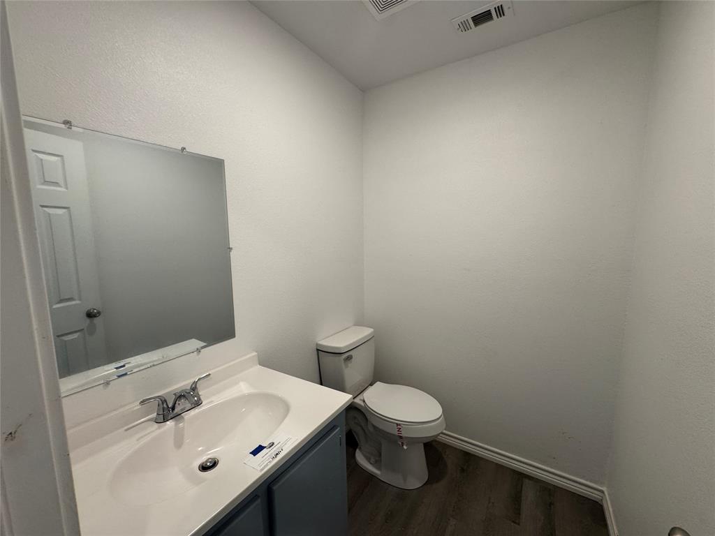 232 West Quanah Road Mabank, TX 75156 - Photo 8 of 13 White vanity with integrated sink and chrome faucet, set against a large wall-mounted mirror