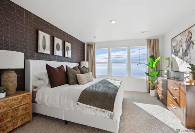 a bedroom with bed and a large window