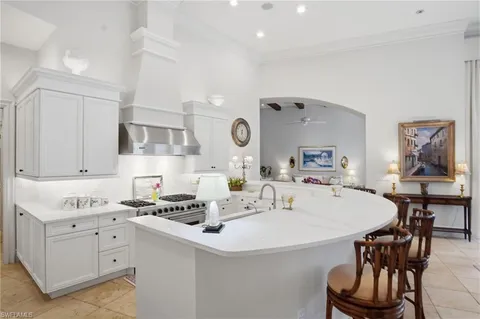 a kitchen with a dining table chairs sink and stove