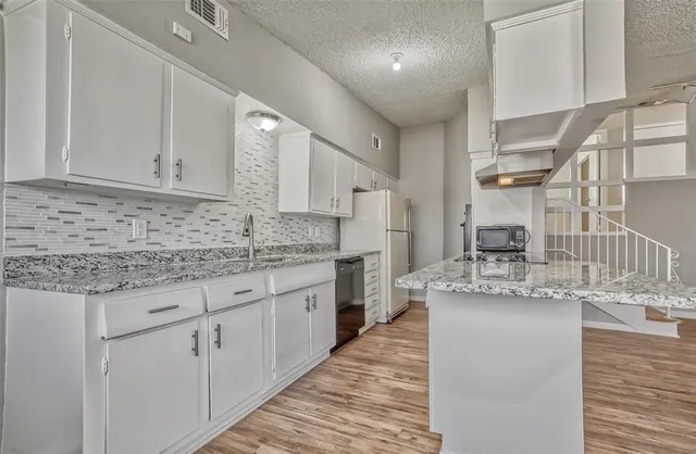 a kitchen with granite countertop white cabinets and a granite counter tops