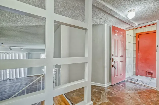 a view of a hallway with wooden floor and staircase