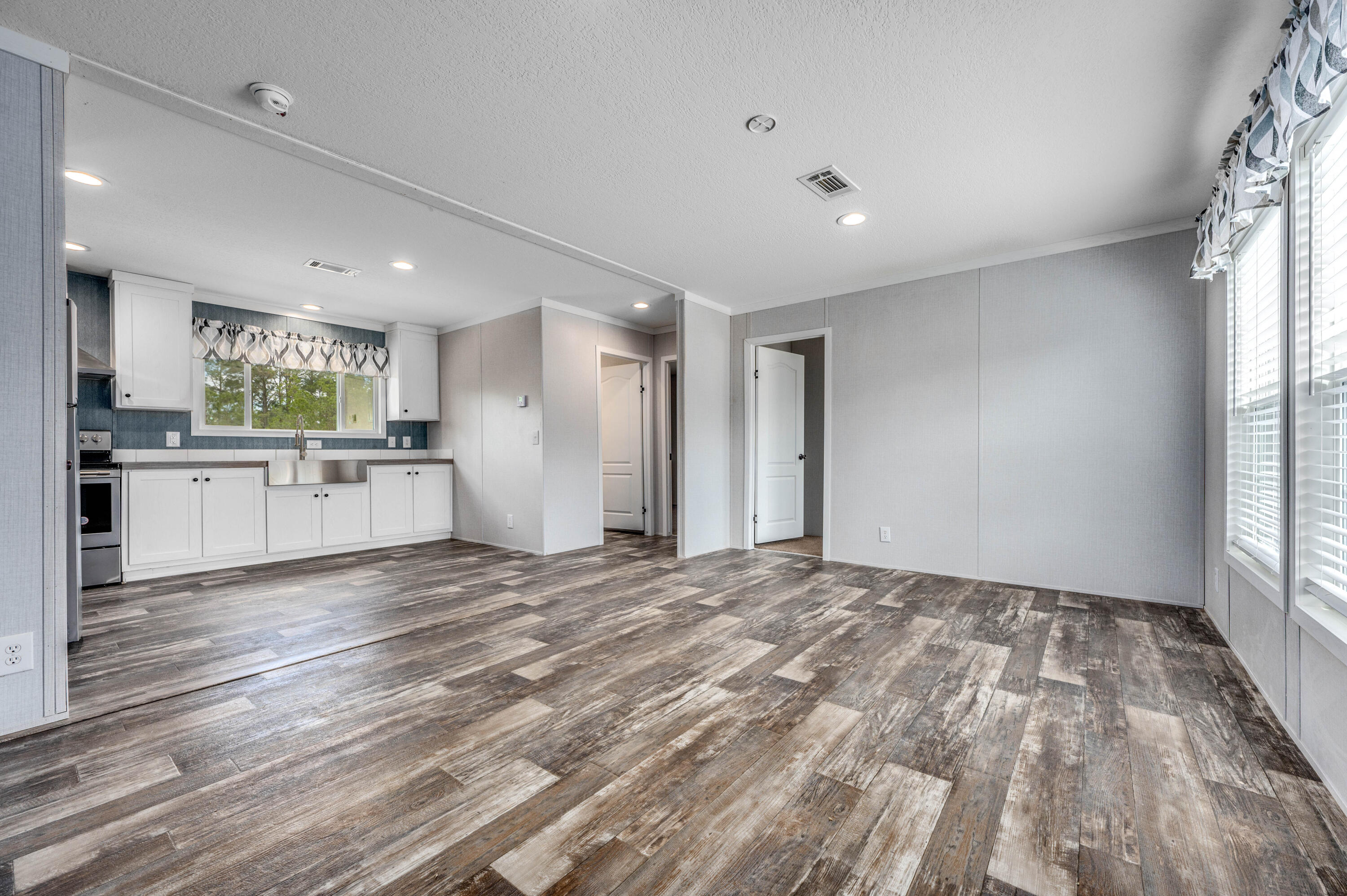 4679 Dove Way Crestview, FL 32539 - Photo 13 of 41 a view of a kitchen with a sink hardwood floor and a large window