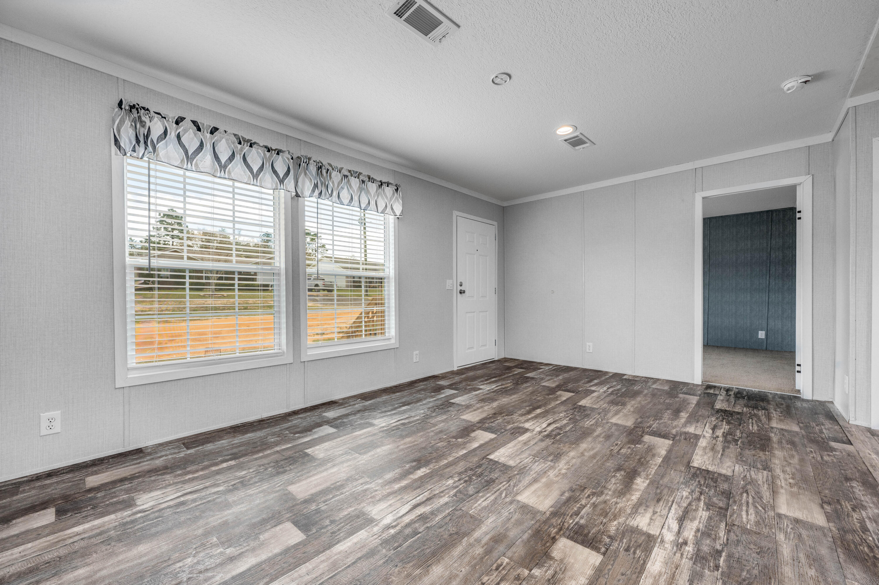 4679 Dove Way Crestview, FL 32539 - Photo 15 of 41 a view of an empty room with a window and wooden floor