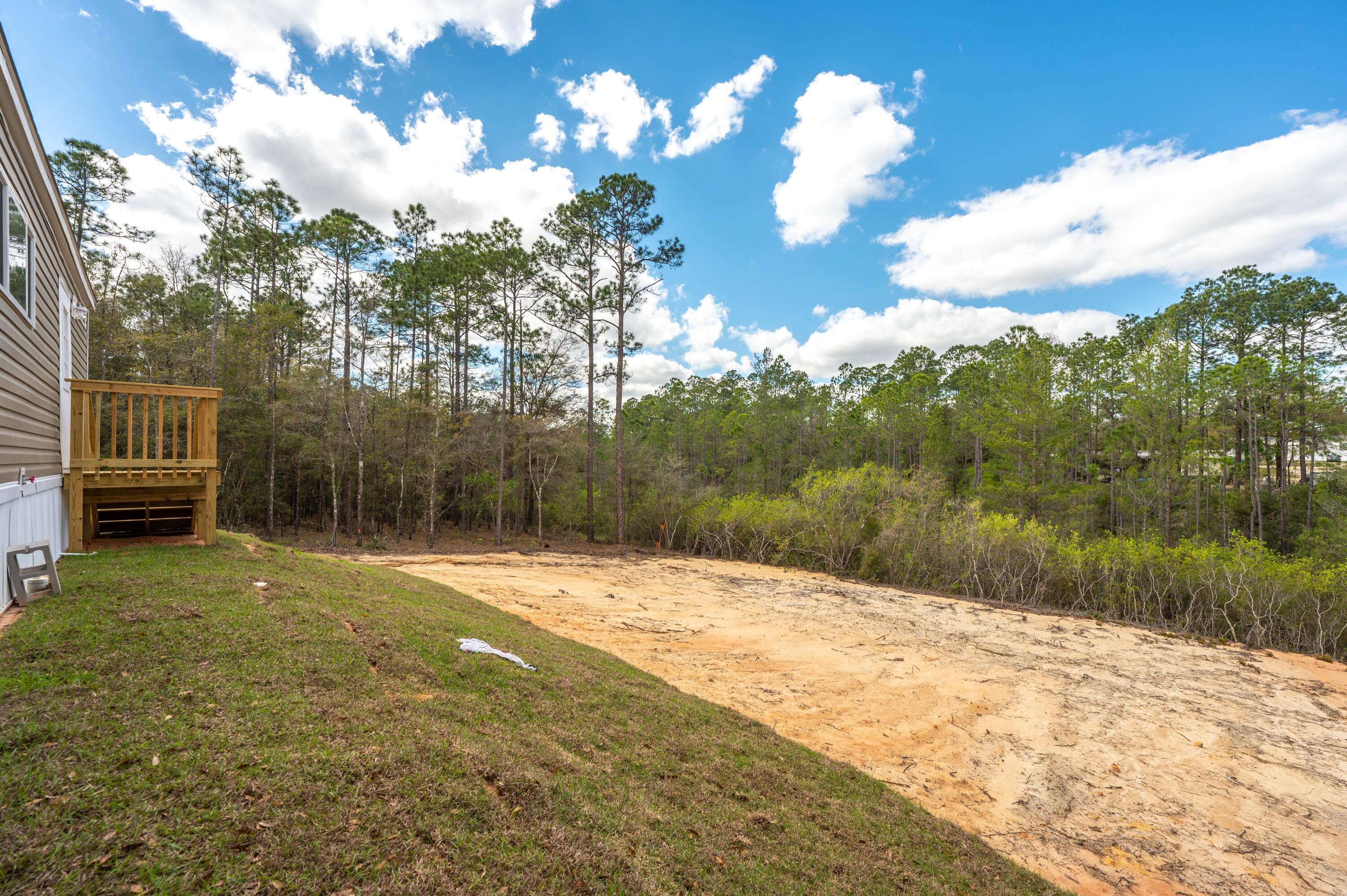 4679 Dove Way Crestview, FL 32539 - Photo 7 of 41 a backyard of a house with lots of green space