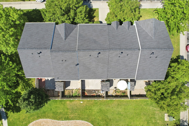 984 Independence Avenue Provo, UT 84604 - Photo 13 of 19 Townhome row with dark gray shingle roofing, individual rear patios, and a shared green space