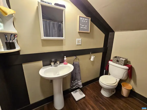 a living room with a bed wooden floor and furniture