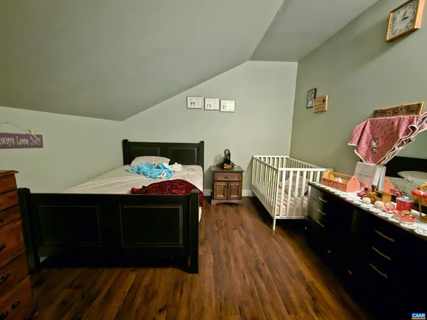 a walk in closet with wooden floor