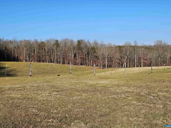 a view of a field with trees in the background