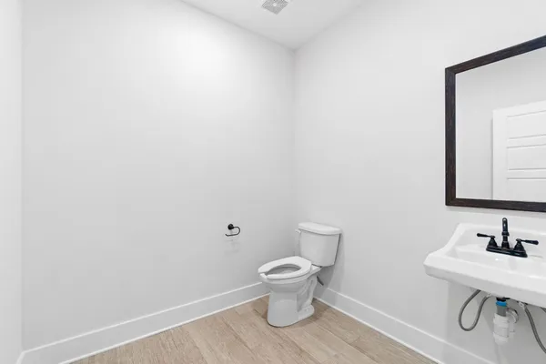 a bathroom with a toilet a sink and mirror