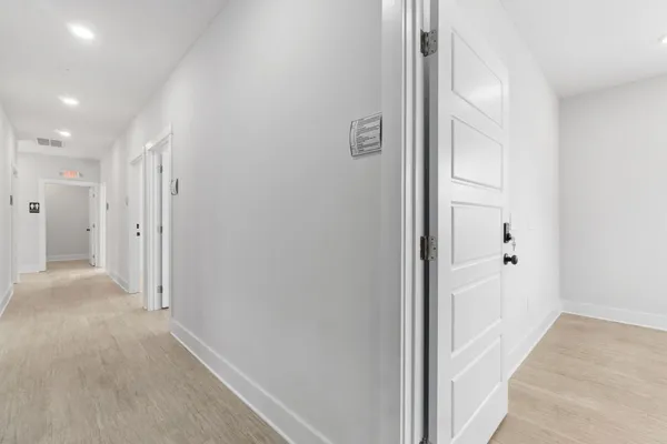a view of a hallway with wooden floor