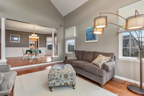 a dining room with furniture a chandelier and wooden floor