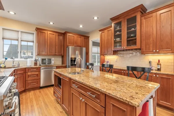 a kitchen with stainless steel appliances granite countertop a stove refrigerator sink and cabinets