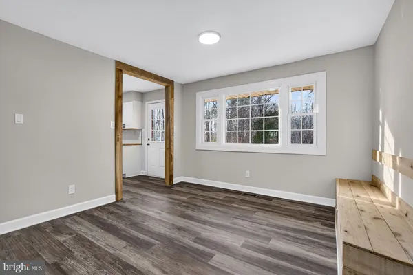 a view of empty room with wooden floor and ceiling fan
