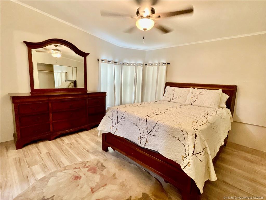 16398 Southwest Two Wood Way Indiantown, FL 34956 - Photo 12 of 24 a bedroom with a large bed and a dresser