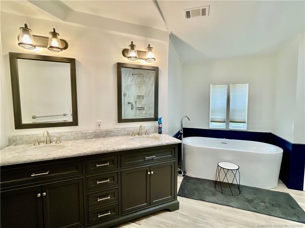 16398 Southwest Two Wood Way Indiantown, FL 34956 - Photo 14 of 24 a bathroom with double vanity sinks and a bathtub