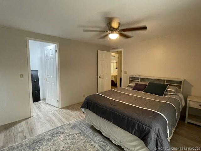 16398 Southwest Two Wood Way Indiantown, FL 34956 - Photo 17 of 24 a bedroom with a bed and a chandelier