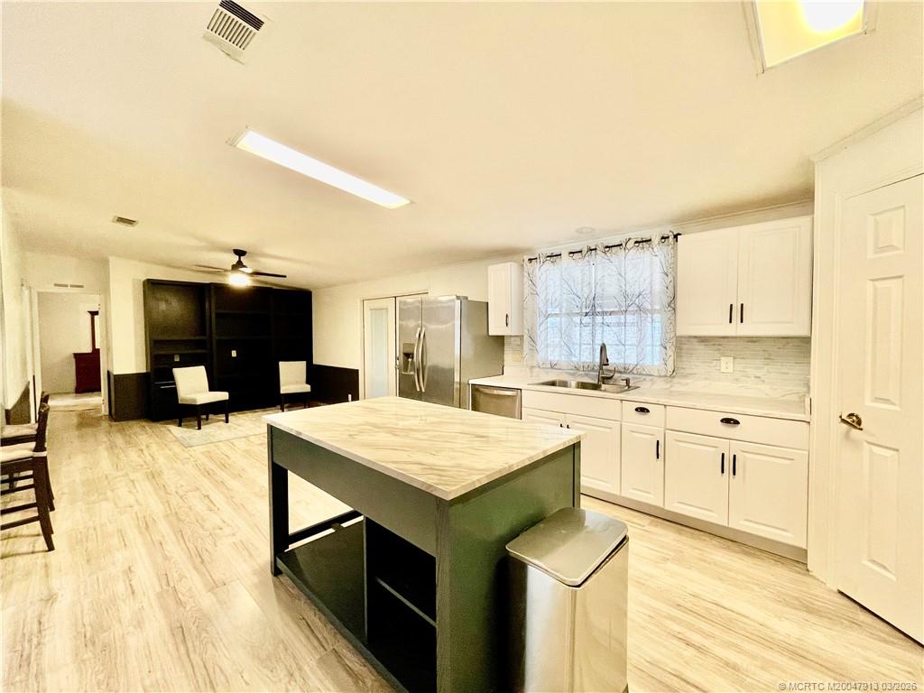16398 Southwest Two Wood Way Indiantown, FL 34956 - Photo 6 of 24 a kitchen with a stove a sink dishwasher and a refrigerator with wooden floor