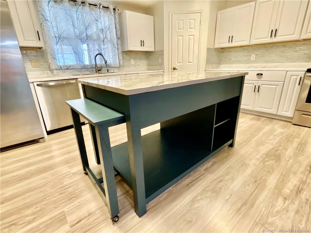 16398 Southwest Two Wood Way Indiantown, FL 34956 - Photo 7 of 24 a kitchen with stainless steel appliances granite countertop a sink stove and cabinets