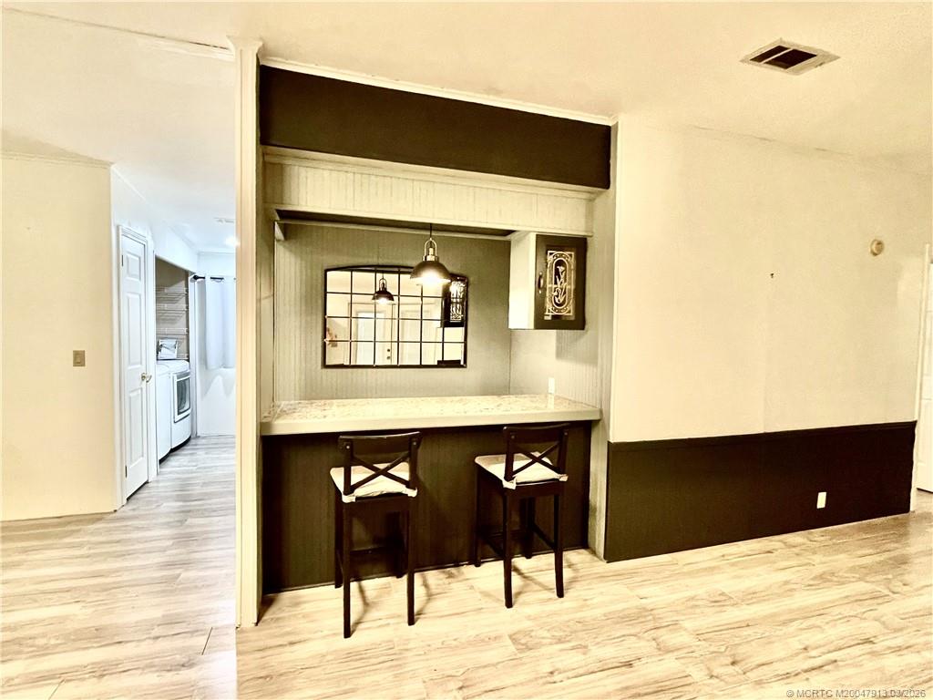16398 Southwest Two Wood Way Indiantown, FL 34956 - Photo 8 of 24 a living room with a wooden floor and a fireplace