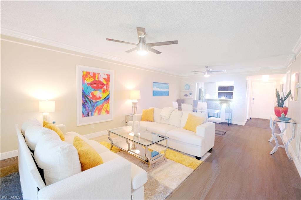 5499 Rattlesnake Hammock Road, Unit A105 Naples, FL 34113 - Photo 1 of 23 Living room featuring crown molding, ceiling fan, a textured ceiling, and hardwood / wood-style floors