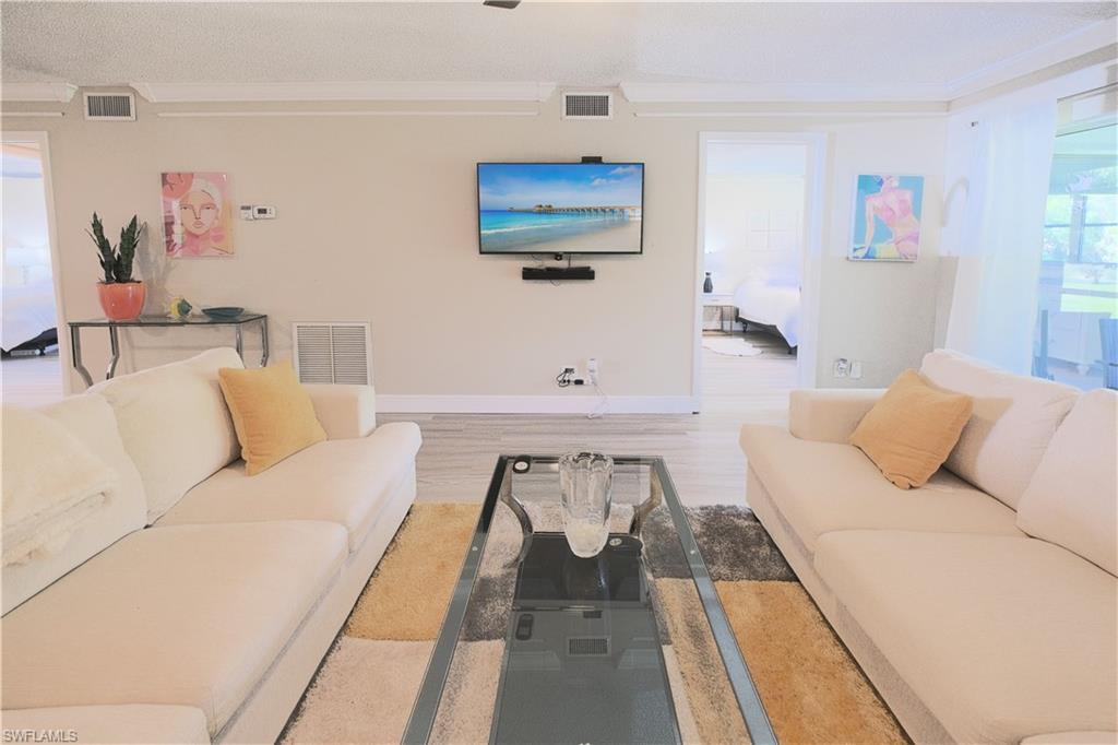 5499 Rattlesnake Hammock Road, Unit A105 Naples, FL 34113 - Photo 11 of 23 Living room with hardwood / wood-style flooring and crown molding