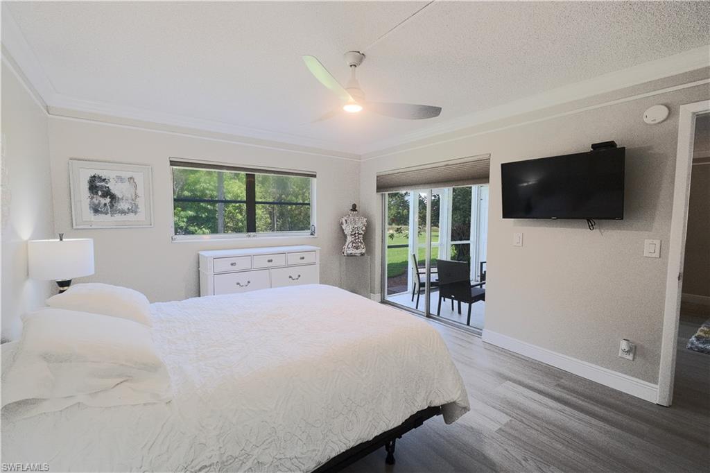 5499 Rattlesnake Hammock Road, Unit A105 Naples, FL 34113 - Photo 13 of 23 Bedroom with access to outside, hardwood / wood-style flooring, ornamental molding, and ceiling fan