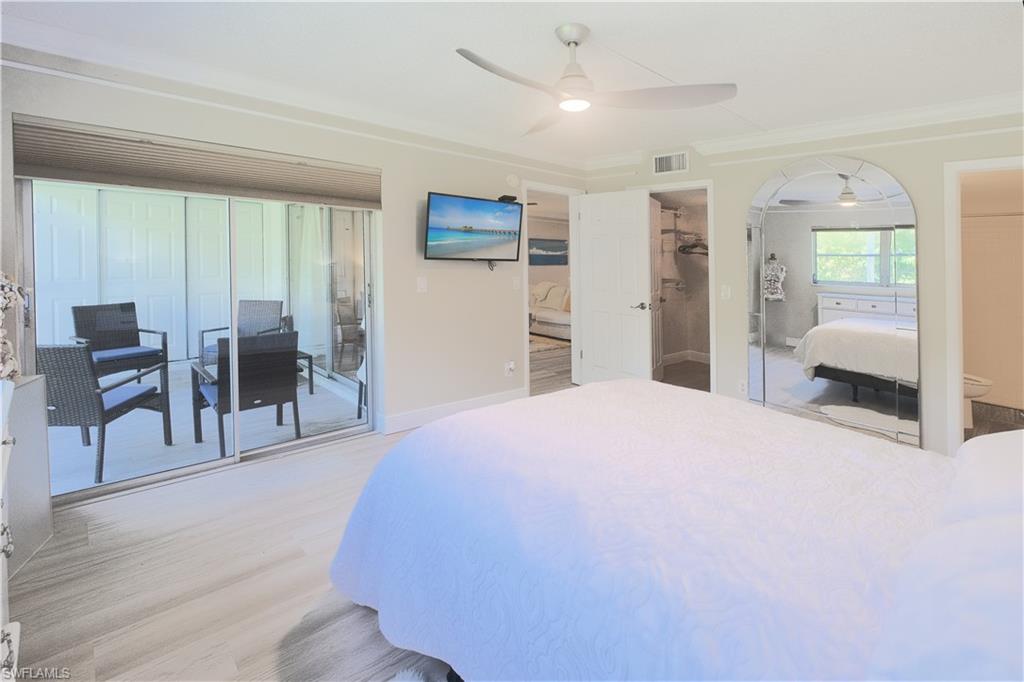 5499 Rattlesnake Hammock Road, Unit A105 Naples, FL 34113 - Photo 14 of 23 Bedroom with light hardwood / wood-style flooring, access to exterior, a spacious closet, a closet, and ceiling fan