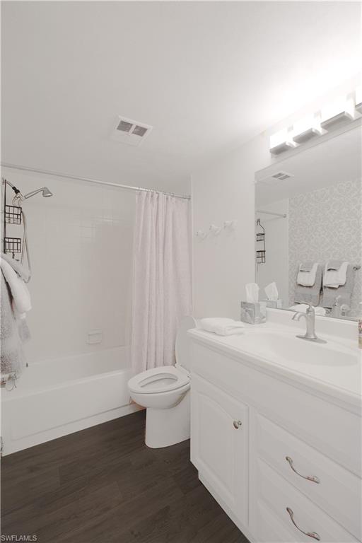 5499 Rattlesnake Hammock Road, Unit A105 Naples, FL 34113 - Photo 18 of 23 Full bathroom featuring hardwood / wood-style flooring, vanity, toilet, and shower / tub combo