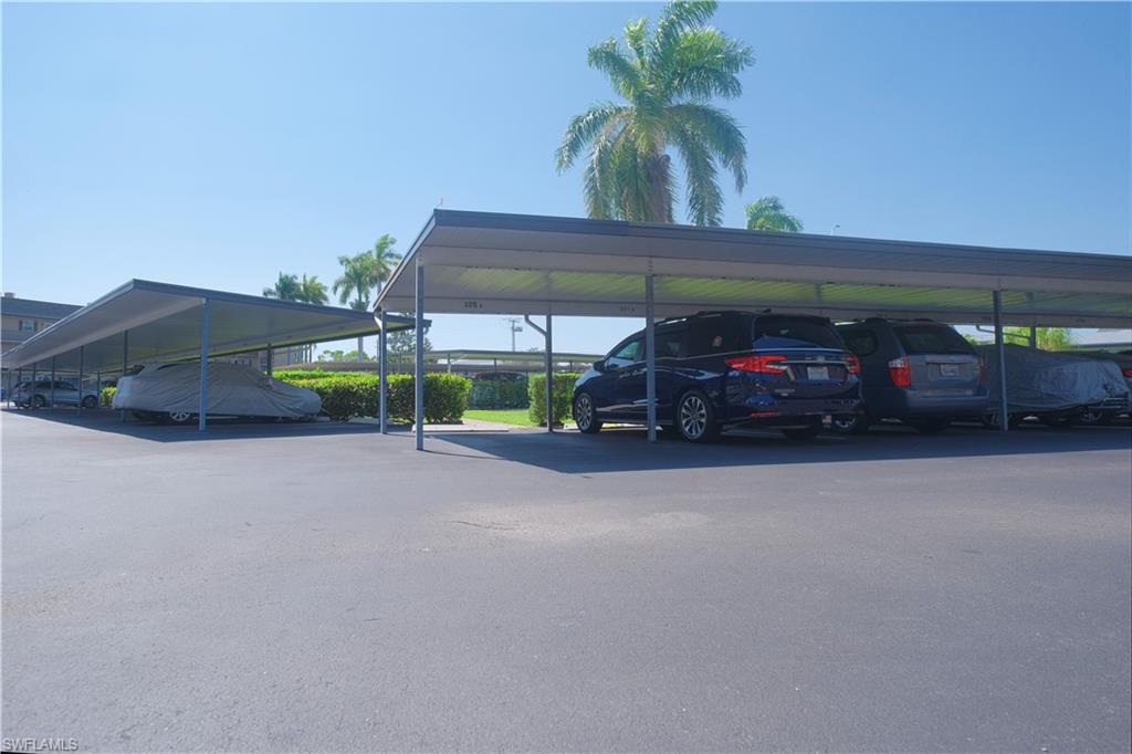 5499 Rattlesnake Hammock Road, Unit A105 Naples, FL 34113 - Photo 20 of 23 View of car parking with a carport