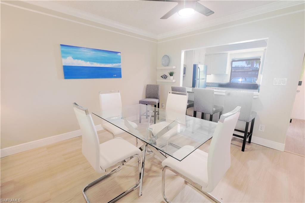 5499 Rattlesnake Hammock Road, Unit A105 Naples, FL 34113 - Photo 8 of 23 Dining area with glass table, ceiling fan, and light hardwood / wood-style flooring
