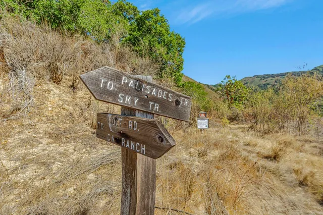 a view of a dry yard with mountains in the background