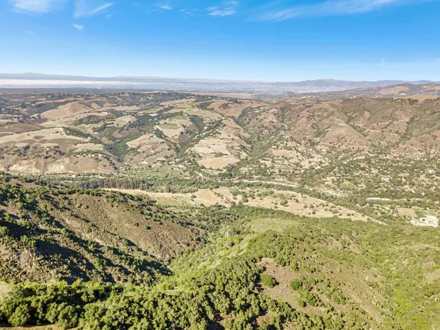 a view of a dry yard with mountains in the background