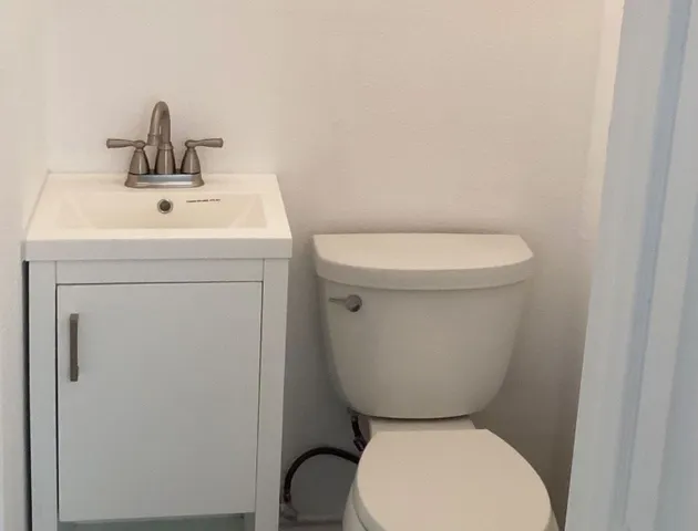 a bathroom with a sink a toilet and a mirror