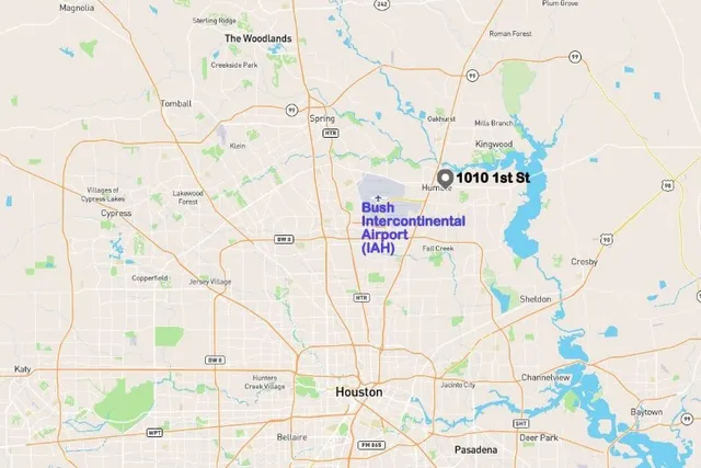 a view of an empty room with wooden floor and a mirror