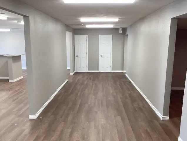 a view of an empty room with wooden floor