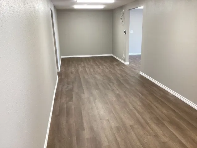 a view of an empty room with wooden floor
