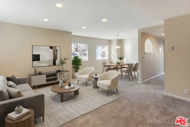 a living room with furniture and view of kitchen
