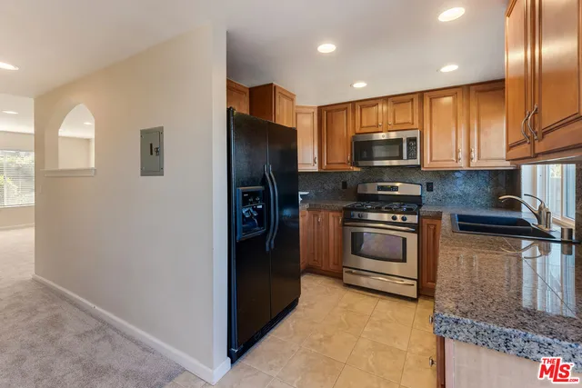 a kitchen with stainless steel appliances granite countertop a refrigerator stove and oven