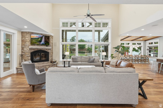 672 Perry Hollow Drive Mapleton, UT 84664 - Photo 22 of 106 Great room featuring a floor-to-ceiling stone fireplace, high vaulted ceilings, and wood-finish flooring