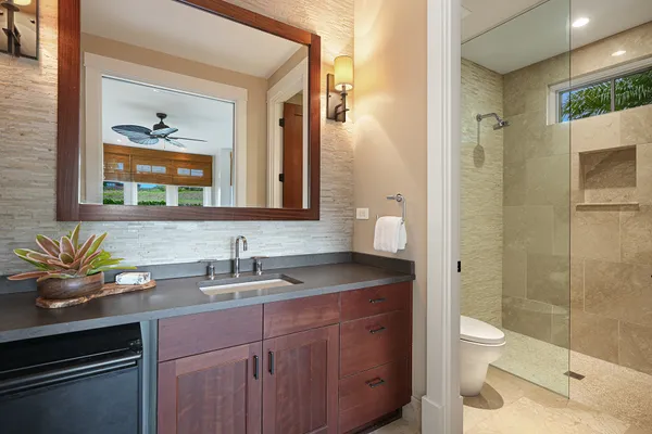 a bathroom with a granite countertop sink a toilet and a mirror