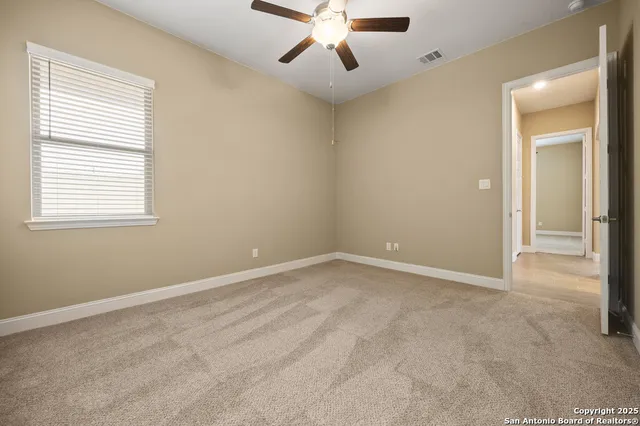 an empty room with a window and a fan