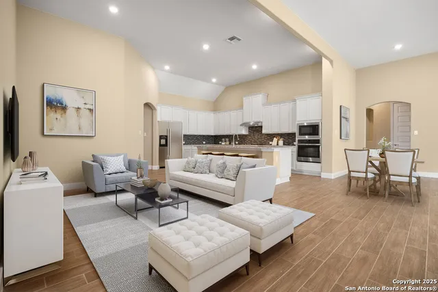 a living room with furniture and a wooden floor