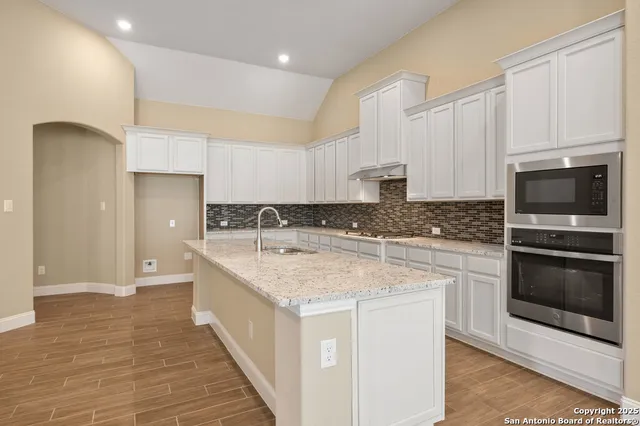 a kitchen with a sink stove and cabinets