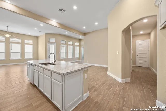 a kitchen with granite countertop a sink and a stove top oven