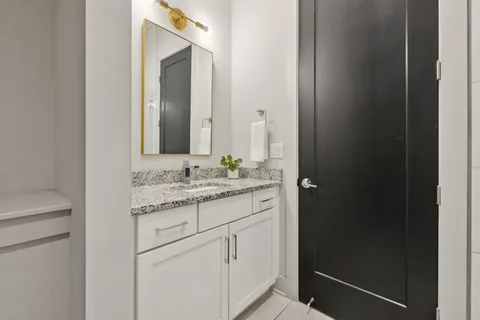 a bathroom with a granite countertop sink and a mirror