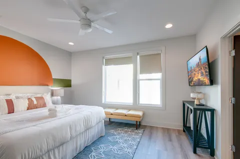 a bedroom with a bed and a painting on the wall